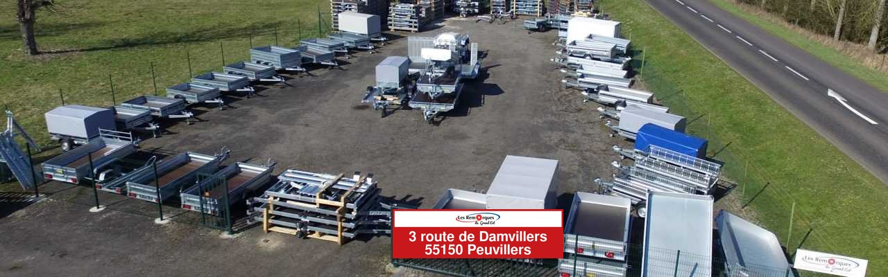 Vue aérienne du dépôt de Peuvillers : des rangées de remorques neuves et la banderole avec l'adresse